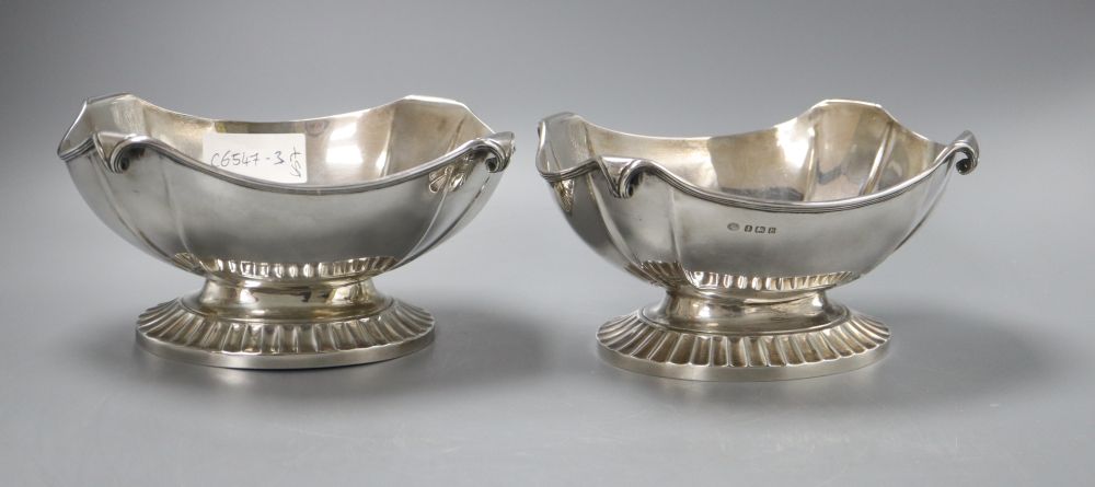 A pair of George V oval silver bowls with scrolling rims and heavy fluted bases, stamped Alexander Clark Co London, but hallmarked for